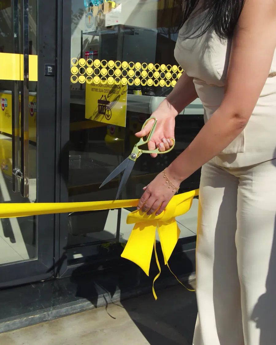 Franqueada corta a fita de inauguração na porta da loja
